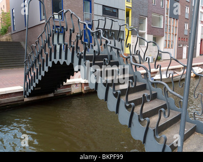 Moderne verzierten stählerne Fußgängerbrücke überqueren Kanal im Neubaugebiet der Insel Java in Amsterdam Niederlande Stockfoto