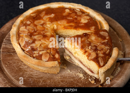 Scheibe abschneiden aus einem Original Bakewell Tart vom Peak District Derbyshire England UK Stockfoto