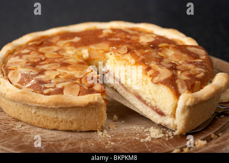 Scheibe abschneiden aus einem Original Bakewell Tart vom Peak District Derbyshire England UK Stockfoto