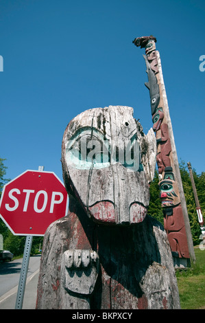 Totempfähle und Stop-Schild am Dorf Saxman Totem Pole Park in der Nähe von Ketchikan, Alaska im Sommer Stockfoto