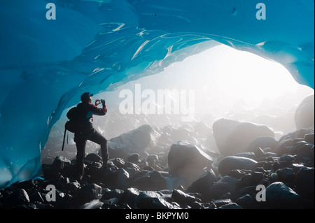 Ein Wanderer nimmt ein Foto von dem Eingang einer Eishöhle aus dem Inneren des Mendenhall Gletscher, südöstlichen Alaska, Sommer Stockfoto