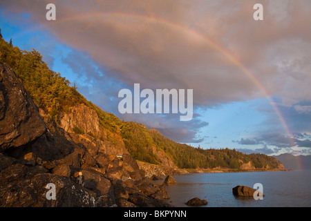 Reizvolle Aussicht auf einen Regenbogen über Turnagain Arm und den Seward Highway bei Sonnenuntergang, Alaska Stockfoto