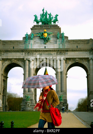 Belgien, Brüssel; Ein Mädchen mit einem Regenschirm vor dem Arc du Triomphe