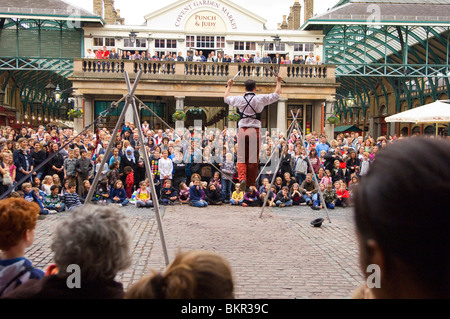 England, London, Covent Garden. A Street Performer auf einem Drahtseil unterhält das Publikum in der Plaza in Covent Garden. Stockfoto