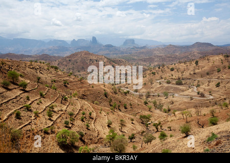 Äthiopien, Simien Berge. Die Hauptstraße durch das zerklüftete Gebirge schlängelt sich durch trockene Terrassenfelder. Stockfoto