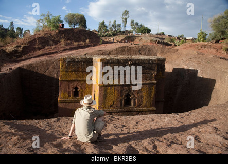 Äthiopien, Lalibela, Bet Giyorgis. Ein Tourist starrt in Fels gehauene Kirche von Bet Giyorgis. (MR) Stockfoto