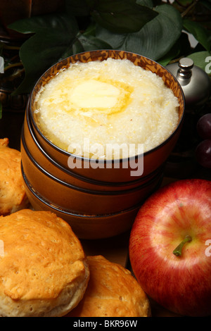 Schale mit heißer Grütze und Butter mit Gebäck und Obst in der Küche. Stockfoto