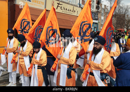 Fünf junge Männer mit Khalsa Fahnen an der Spitze der 12. jährliche Vaisakhi Nagar Kirtan (Prozession) durch Hounslow Middx, UK. Stockfoto