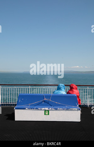 Zwei Passagiere sitzen auf einem blauen Bank nahe an die auf dem Heck der Stena Europa Autofähre, an der irischen See. Stockfoto