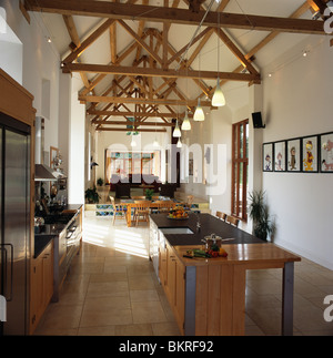Insel-Einheit in modernen Küche in große offene Scheune Konvertierung mit Holzbalken Apex Decke und hängende Beleuchtung Stockfoto
