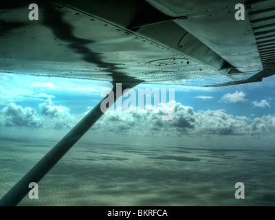 Blick unter die Flügel ein Leichtflugzeug in den Wolken bei einem sehr holprigen Flug über das Meer in West Sussex. Stockfoto