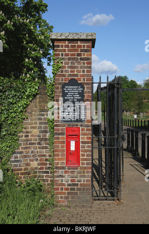 Schinken-Tor zum Richmond Park in Kingston upon Thames. Die gemauerte Säule hat einen roten Royal Mail-Briefkasten und mehrere Zeichen Stockfoto
