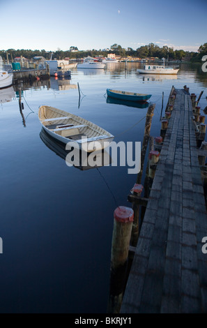 Boote im Hafen von Macquarie, mit der Gemeinde Strahan jenseits Stockfoto