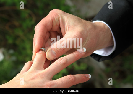 Ehering Bräute Hand von ihrem neuen Ehemann oder des Bräutigams gebracht werden. Diamant-Ring Weissgold-Band. Stockfoto