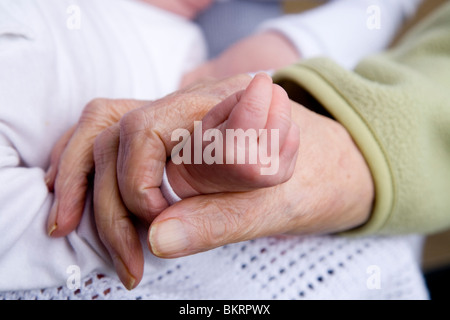 Nahaufnahme von einer älteren Frau Hand an der Hand der ein Neugeborenes / neues Baby geboren. Stockfoto