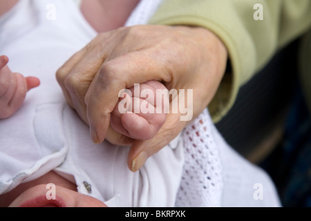 Nahaufnahme von einer älteren Frau Hand an der Hand der ein Neugeborenes / neues Baby geboren. Stockfoto