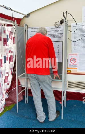 Senior woman Stimmabgabe im Wahllokal in Wohnwagen Markise an Coedkernew in Newport West Wahlkreis South Wales UK Stockfoto