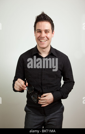 Junger Mann stehen und lachen Stockfoto