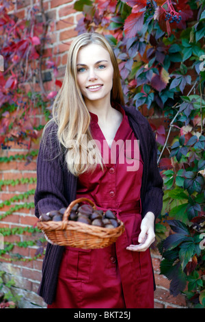 Mädchen mit Korb mit Kastanien Stockfoto