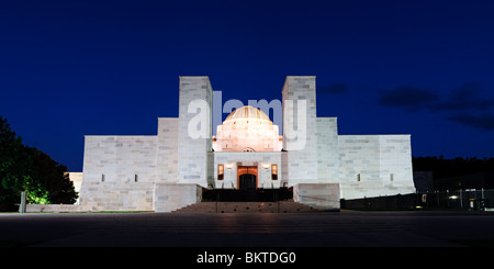 Australian war Memorial bei Nacht beleuchtet Canberra Australien | CANBERRA, Australien – Ein Panoramablick bei Nacht fängt die gesamte Breite des Australian war Memorial Ein, dessen beleuchtete Kuppel sich zwischen zwei Sandsteinmasten am Kopf der Anzac Parade befindet. Das Gebäude wurde 1941 nach einem Entwurf von Emil Sodersten und John Crust fertiggestellt und verankert Walter Burley Griffins zeremonielle Landachse gegenüber dem Parlamentsgebäude. Die Ehrenrolle, die im Kreuzgang des Eingangs gehalten wird, nennt mehr als 103.000 Australier, die seit 1885 im Konflikt ums Leben gekommen sind. Stockfoto