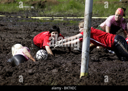 TORHÜTERIN TAUCHT IM SCHLAMM: Der TORHÜTER holt sich den Ball als Team Kamela und Extreme Ladyt bei der Swamp Soccer World Cup in Ukkohalla, Finnland Stockfoto