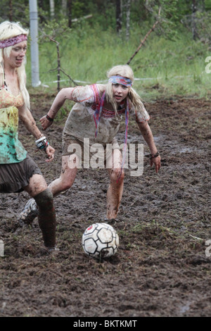 SUMPFFUSSBALL, EXTREMSPORT: Das schicke Kleid ist mit Schlamm bedeckt, als Turbo Urhot Team Asha bei der Sumpffußball-Weltmeisterschaft in Ukkohalla Finnland trifft Stockfoto