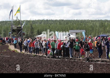 SUMPFFUSSBALL, EXTREMSPORT: Eine große Aufnahme der Zuschauer, die die Gänge zwischen den Spielen beim 13. Jährlichen Sumpffußball-Weltmeisterschaft in Ukkohalla, Finnland, nutzte Stockfoto