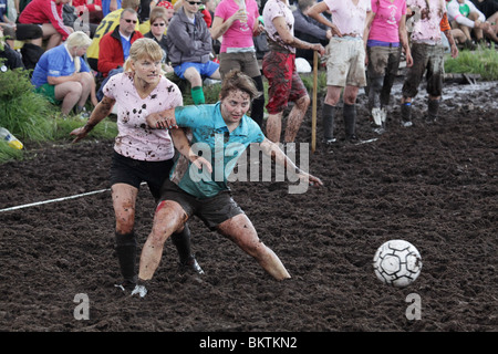 SUMPFFUSSBALL, EXTREMSPORT, FRAUENDUELL: Zwei schlammige Frauen kämpfen um den Ball bei der 13. Jährlichen Sumpffußball-Weltmeisterschaft in Ukkohalla, Finnland Stockfoto