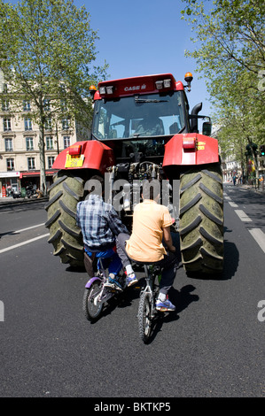 Traktor im Zentrum von Paris, zwei Kinder mit dem Fahrrad nach Stockfoto