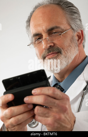 Nahaufnahme eines Arztes trägt Brille und einen Laborkittel und SMS auf einem Handy. Vertikale erschossen. Stockfoto