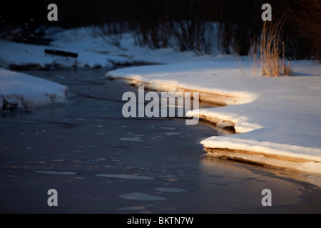 Dünne Eisschicht auf einem kleinen Bach im Winter, Finnland Stockfoto