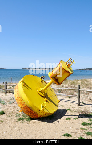 Gelbe Fahrwassermarkierung am Strand in Wellfleet Harbor, Cape Cod Massachusetts, USA Stockfoto