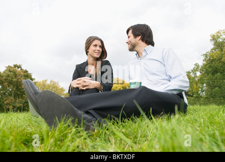 Mann und Frau sitzen auf Rasen Stockfoto