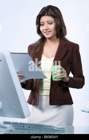 Geschäftsfrau sucht im Dokument, Lächeln, Porträt Stockfoto