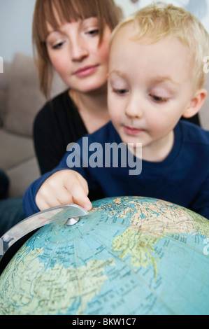 Mutter und Sohn suchen im globe Stockfoto