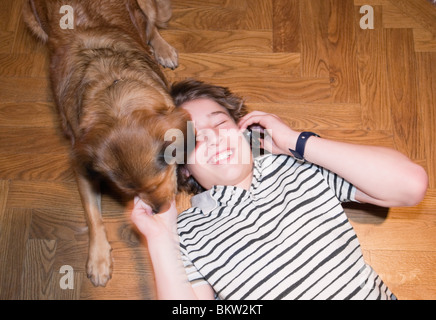 Teenageguy mit Hund und Handy Stockfoto