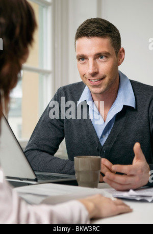 Mann im Gespräch mit Frau am Schalter Stockfoto