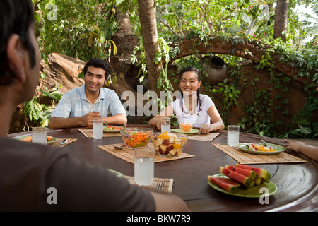 Freunde sitzen im Freien, Tisch, sprechen und Lächeln Stockfoto