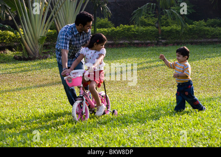 Tochter lernen Fahrrad mit ihrem Vater, Sohn, jagen Stockfoto