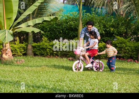 Tochter lernen Fahrrad mit ihrem Vater, Sohn, jagen Stockfoto