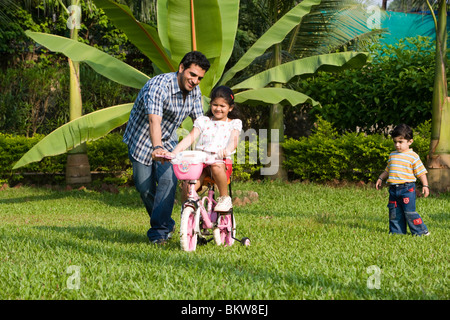 Tochter lernen Fahrrad mit ihrem Vater, Sohn, jagen Stockfoto