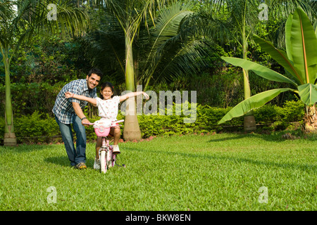 Tochter lernen Fahrrad mit ihrem Vater Stockfoto