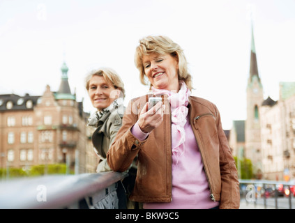 Frauen auf der Brücke mit Handy Stockfoto
