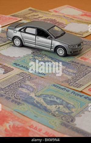 Spielzeugauto auf indische Rupie Banknoten Stockfoto