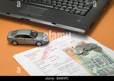 Spielzeugauto mit Kreditantragsformular, indische Rupien und einen laptop Stockfoto