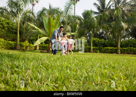 Sohn, Fahrrad mit ihrem Vater, Tochter jagen lernen Stockfoto