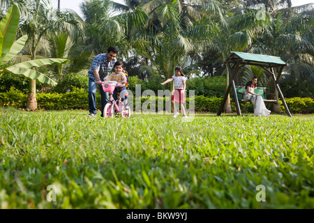 Sohn, Fahrrad mit ihrem Vater, Tochter jagen lernen Stockfoto