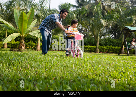 Sohn, Fahrrad mit ihrem Vater, Tochter jagen lernen Stockfoto