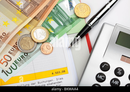 Euro-Münzen und Scheine mit Taschenrechner und Kugelschreiber auf Kontoauszug Stockfoto