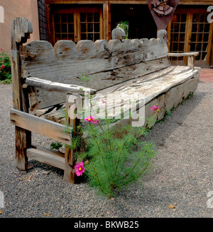 Alte Holzbank und Blumen in einem Garten entlang der Canyon Road, Ort von Galerien & Geschäften, Santa Fe, New Mexico, USA Stockfoto